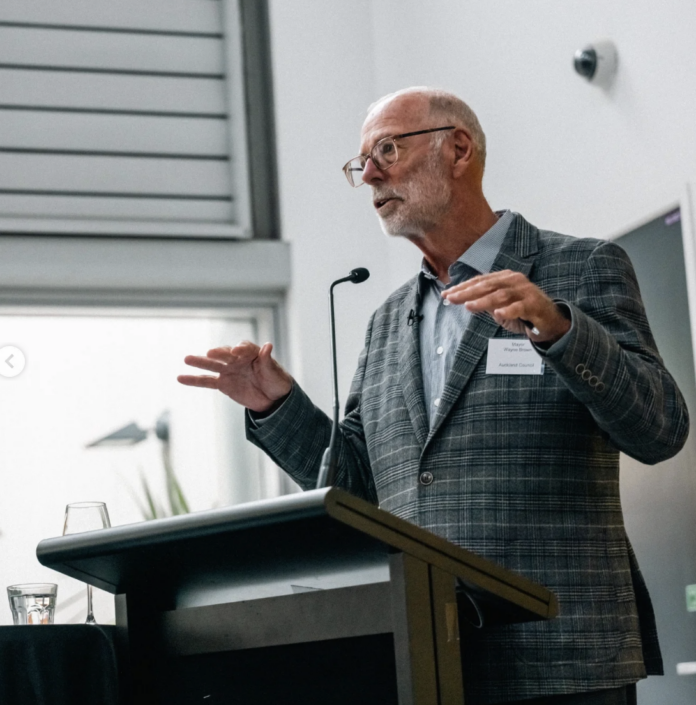 Auckland Mayor Wayne Brown gesturing with both hands while speaking at a lectern