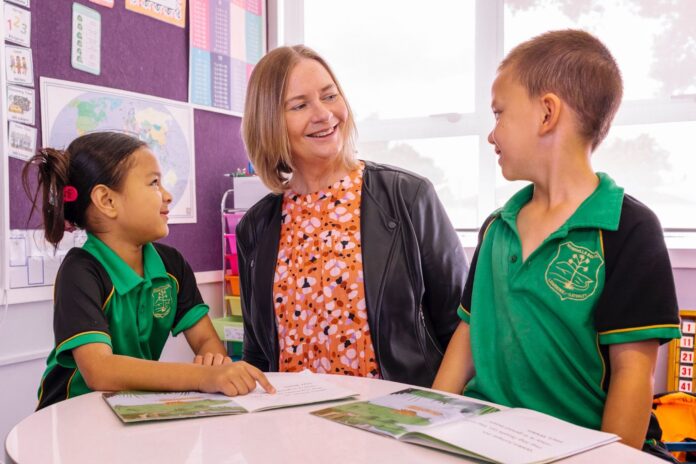 Riverhills School principal Sarah Allen in a classroom with two pupils.