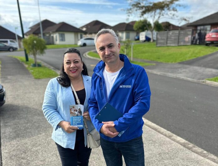 Rima Nakhle and her husband Roger standing on a footpath in Donegal Park holding campaign material